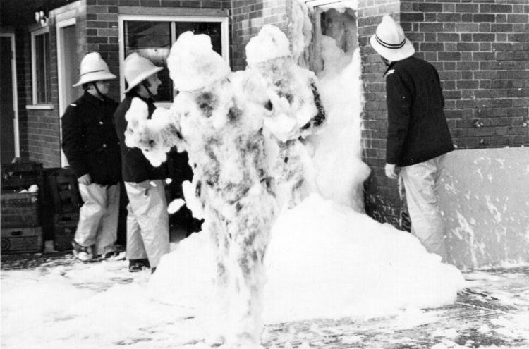 Two crew members leave the drill tower which had been filled with high expansion foam