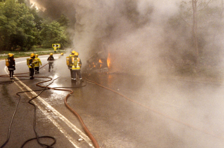 Crews in breathing apperatus tackle the burning dustcart